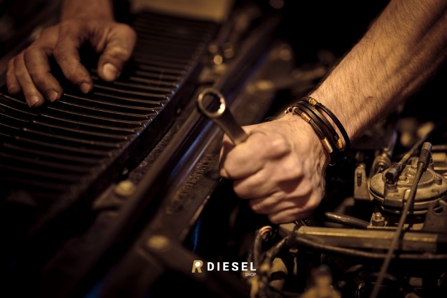 Meccanico con chiave inglese al lavoro su di un motore