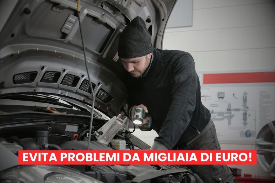 Meccanico che ispeziona all'interno del cofano di un auto